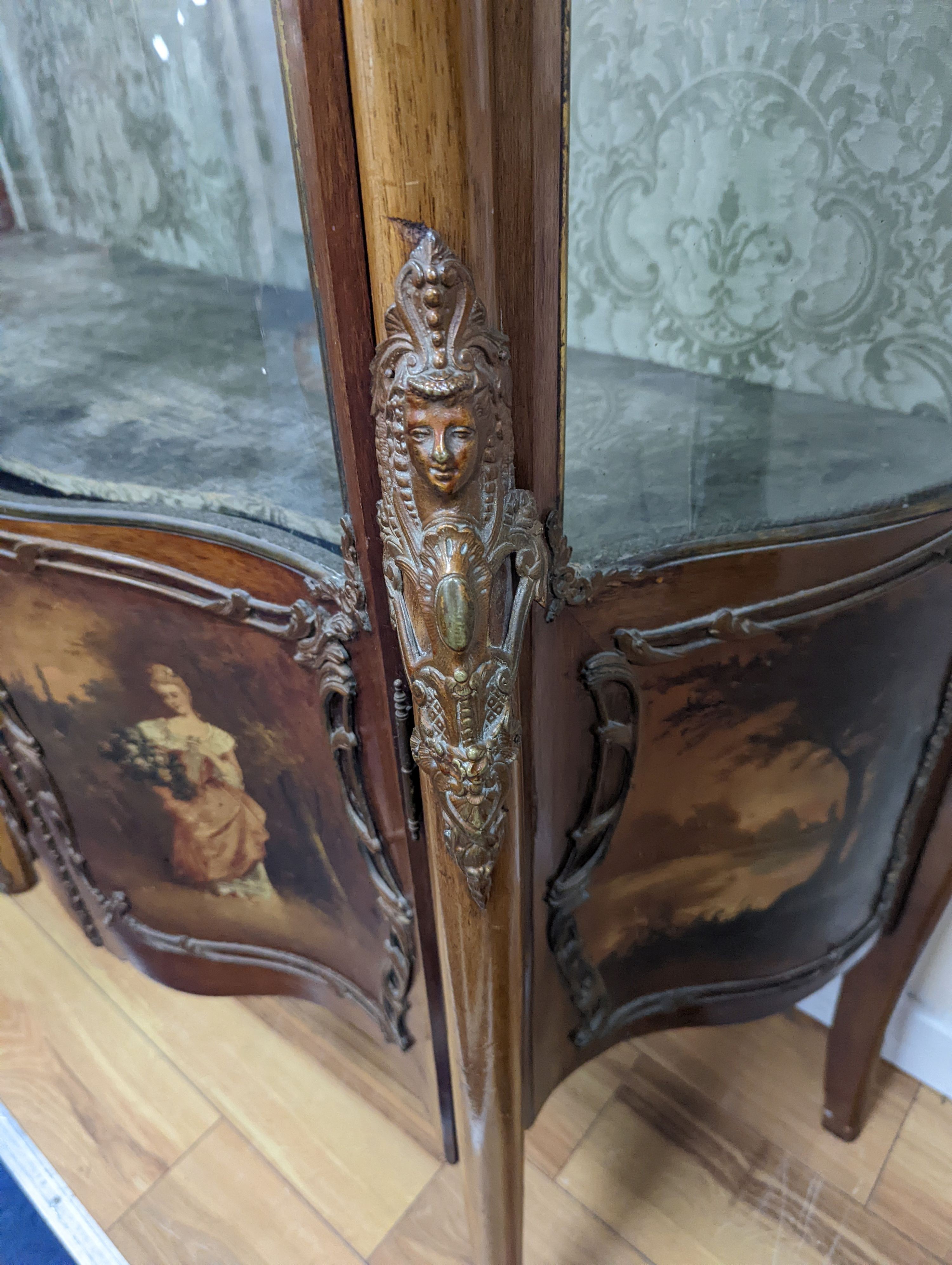 A Louis XV style mahogany serpentine vitrine with Vernis Martin style panels and gilt metal mounts, width 108cm, depth 46cm, height 193cm